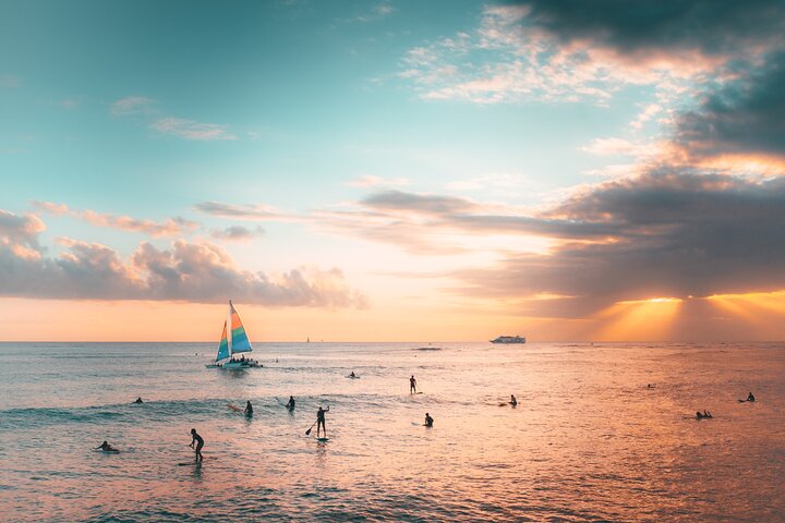 a group of people on a beach with a sunset in the background