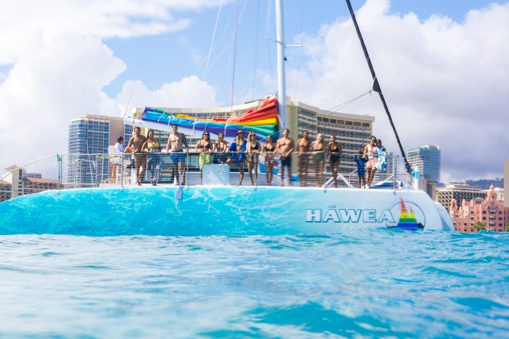 a blue and white boat sitting next to a body of water